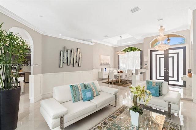16601 SW 87th Ct, Palmetto Bay, FL 33157 - living room featuring crown molding, arched walkways, wainscoting, and a decorative wall