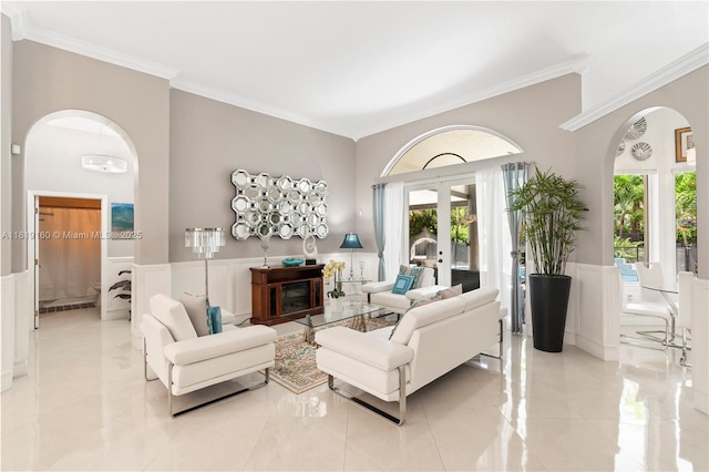 16601 SW 87th Ct, Palmetto Bay, FL 33157 - living room with arched walkways, crown molding, plenty of natural light, wainscoting, and french doors