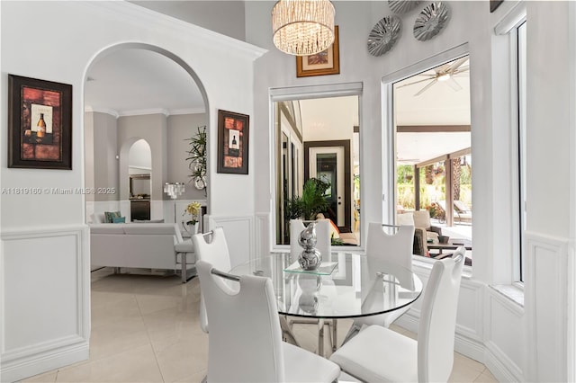 16601 SW 87th Ct, Palmetto Bay, FL 33157 - dining area with a decorative wall, arched walkways, a wainscoted wall, light tile patterned floors, and ornamental molding