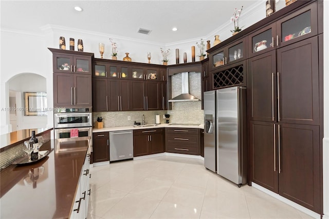 16601 SW 87th Ct, Palmetto Bay, FL 33157 - kitchen featuring wall chimney range hood, stainless steel appliances, crown molding, backsplash, and arched walkways
