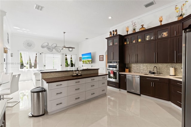 16601 SW 87th Ct, Palmetto Bay, FL 33157 - kitchen featuring appliances with stainless steel finishes, ornamental molding, decorative backsplash, dark brown cabinets, and glass insert cabinets
