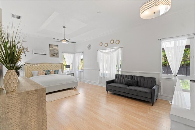 16601 SW 87th Ct, Palmetto Bay, FL 33157 - bedroom with a raised ceiling, multiple windows, light wood finished floors, a decorative wall, and a wainscoted wall