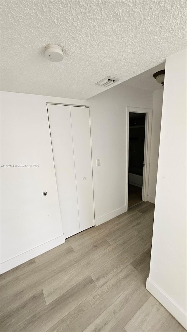 608 NE 2nd St Unit 133, Dania Beach, FL 33004 - hallway with light wood-style floors and a textured ceiling