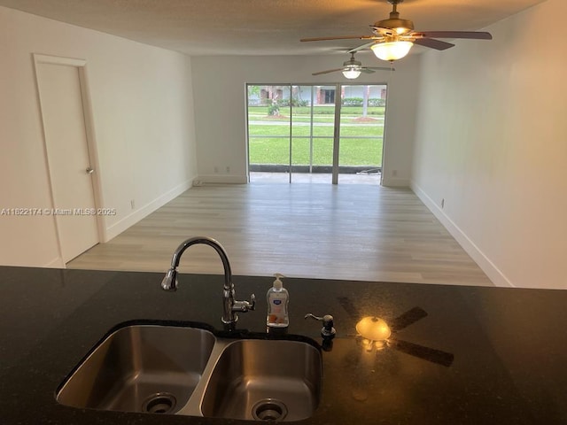 608 NE 2nd St Unit 133, Dania Beach, FL 33004 - kitchen view of light wood-style flooring, ceiling fan, dark countertops, and white cabinets