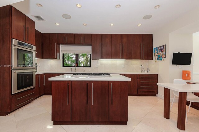 6535 Allison Rd, Miami Beach, FL 33141 - kitchen with double oven, white gas cooktop, tasteful backsplash, light countertops, and recessed lighting