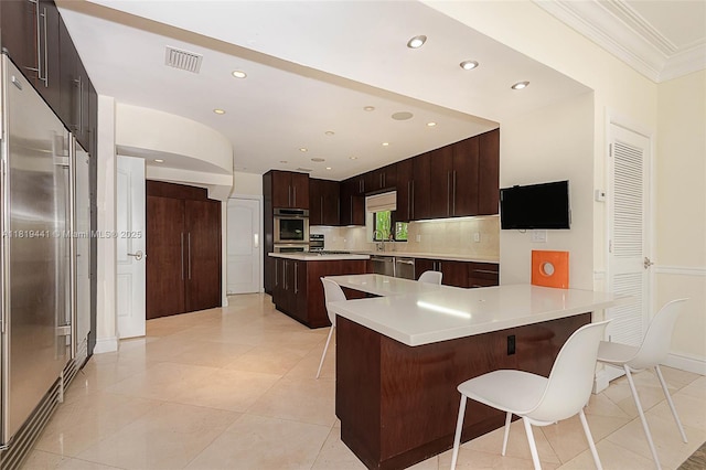 6535 Allison Rd, Miami Beach, FL 33141 - kitchen featuring a kitchen breakfast bar, built in fridge, ornamental molding, recessed lighting, and a peninsula
