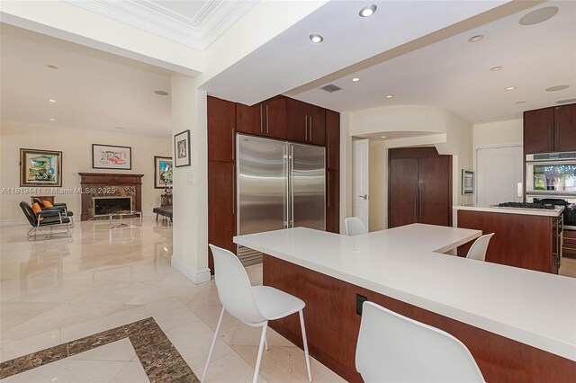 6535 Allison Rd, Miami Beach, FL 33141 - kitchen with stainless steel appliances, a center island, recessed lighting, a breakfast bar area, and a fireplace