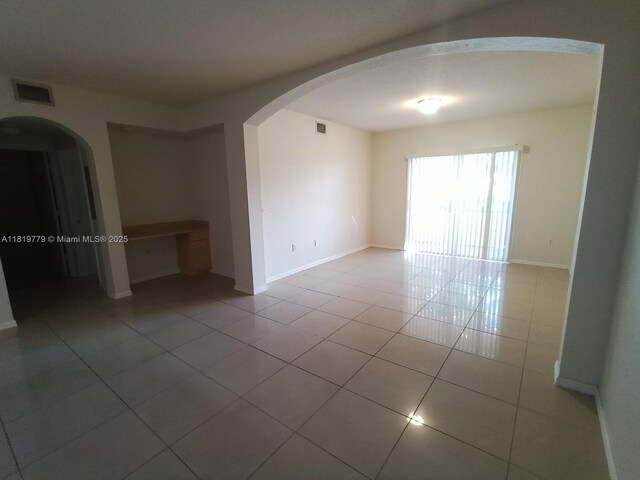 503 Belmont Ln Unit 503, North Lauderdale, FL 33068 - empty room with arched walkways and tile patterned flooring