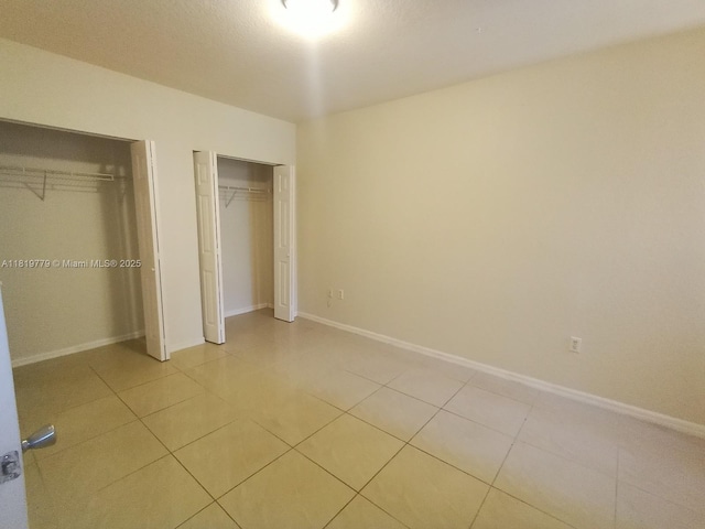503 Belmont Ln Unit 503, North Lauderdale, FL 33068 - unfurnished bedroom featuring multiple closets and light tile patterned flooring