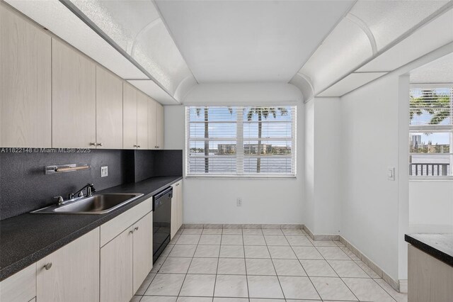2851 NE 183rd St Unit 216E, Aventura, FL 33160 - kitchen featuring dishwasher, dark countertops, backsplash, light tile patterned floors, and vaulted ceiling