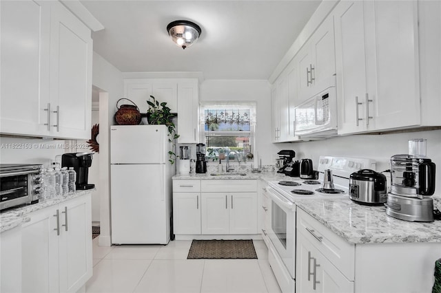 7502 NW 30th Pl Unit 112, Sunrise, FL 33313 - kitchen featuring white appliances, white cabinetry, light tile patterned floors, and light stone countertops