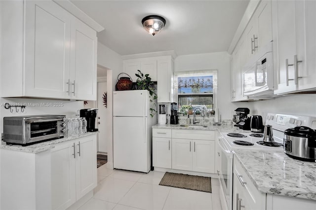 7502 NW 30th Pl Unit 112, Sunrise, FL 33313 - kitchen featuring white appliances, white cabinetry, light tile patterned floors, and light stone countertops