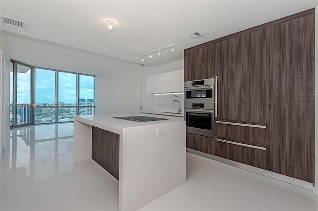 851 NE 1st Ave Unit 1608, Miami, FL 33132 - kitchen with modern cabinets, black electric stovetop, a kitchen island, and expansive windows