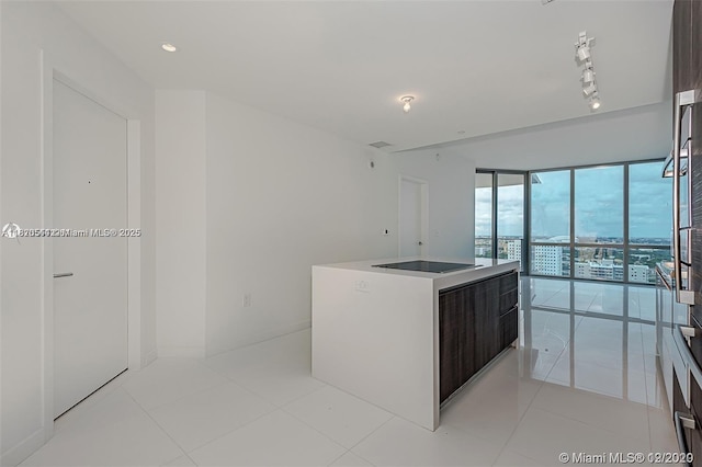 851 NE 1st Ave Unit 1608, Miami, FL 33132 - kitchen with a center island, modern cabinets, black electric cooktop, and light tile patterned flooring