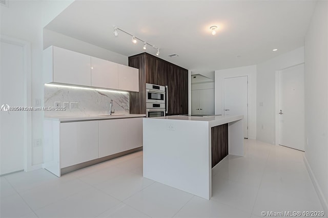 851 NE 1st Ave Unit 1608, Miami, FL 33132 - kitchen featuring modern cabinets, white cabinets, stainless steel double oven, and light countertops