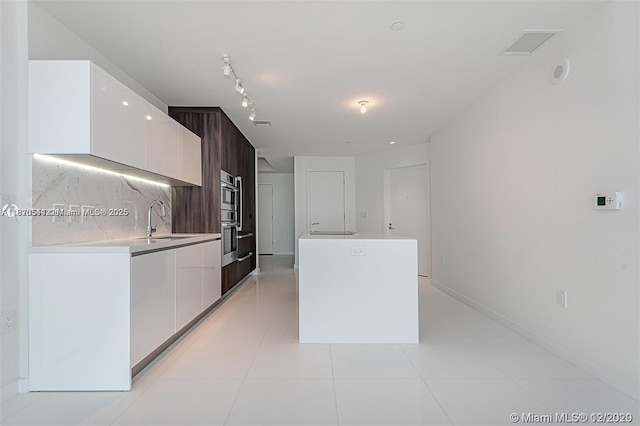 851 NE 1st Ave Unit 1608, Miami, FL 33132 - kitchen with modern cabinets, white cabinetry, a center island, and light countertops