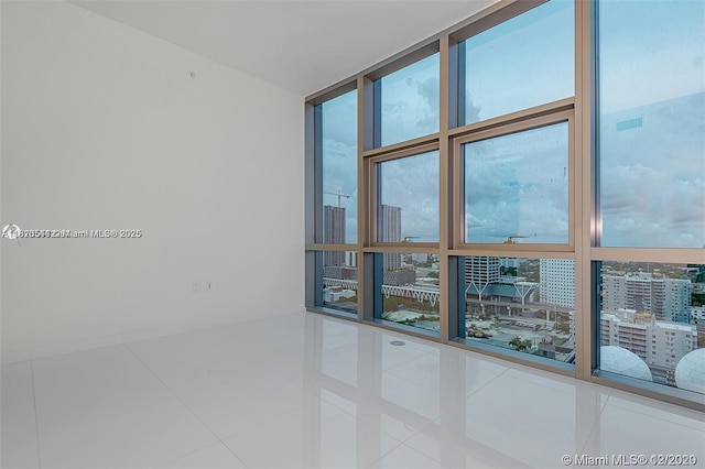 851 NE 1st Ave Unit 1608, Miami, FL 33132 - spare room with expansive windows, healthy amount of natural light, a view of city, and tile patterned flooring