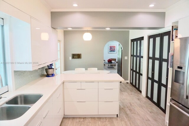 13200 SW 59th Ave, Pinecrest, FL 33156 - kitchen with stainless steel refrigerator with ice dispenser, a peninsula, light wood finished floors, modern cabinets, and crown molding