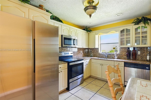 7420 SW 14th Pl, North Lauderdale, FL 33068 - kitchen with stainless steel appliances, tasteful backsplash, glass insert cabinets, a textured ceiling, and light tile patterned floors