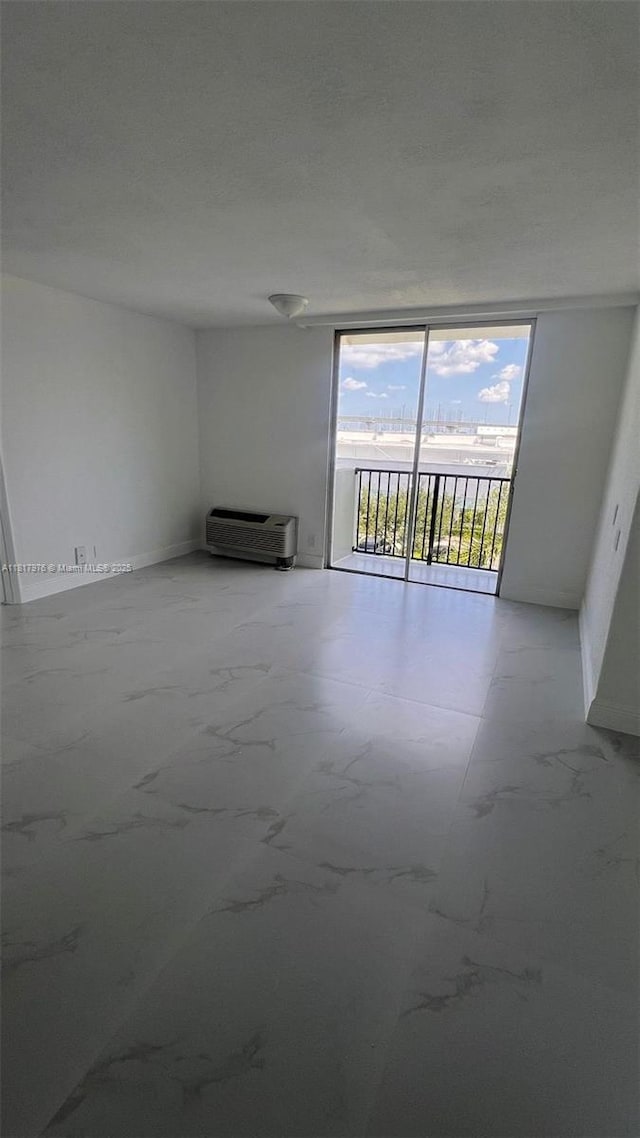 16450 NW 2nd Ave Unit 409, Miami, FL 33169 - spare room with a wall of windows and an AC wall unit