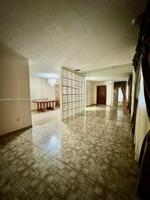 2671 SW 107th Ave, Miami, FL 33165 - empty room with a chandelier and a textured ceiling