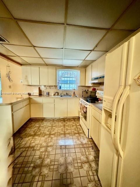 2671 SW 107th Ave, Miami, FL 33165 - kitchen with white appliances, a paneled ceiling, under cabinet range hood, light countertops, and light flooring