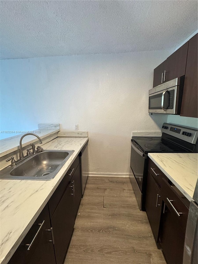1225 NE 124th St Unit 46A, North Miami, FL 33161 - kitchen featuring stainless steel appliances, dark wood finished floors, a textured ceiling, light countertops, and dark brown cabinetry
