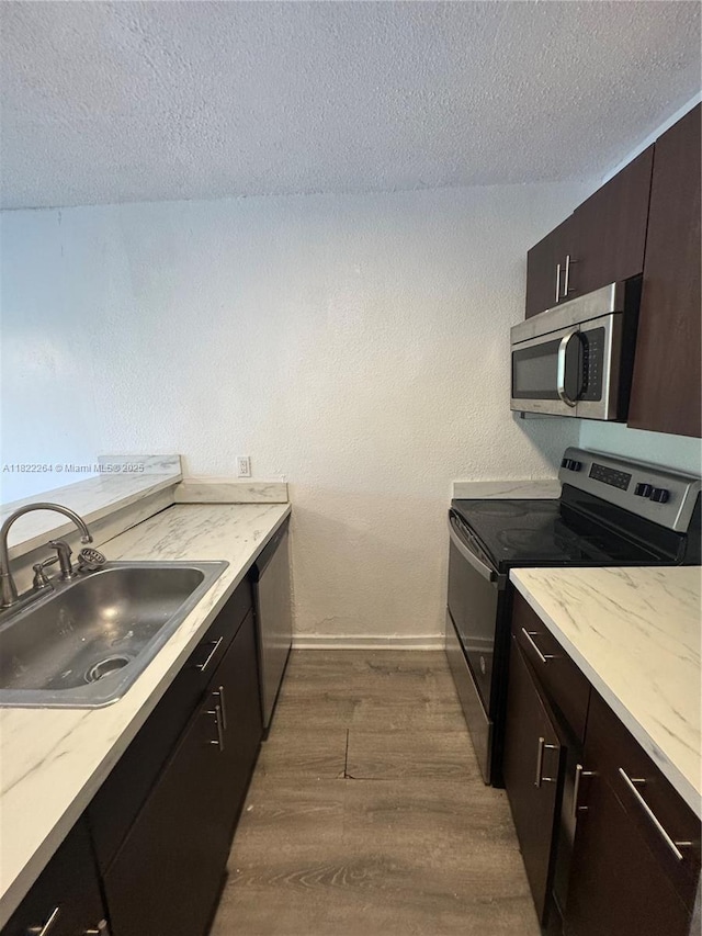 1225 NE 124th St Unit 46A, North Miami, FL 33161 - kitchen featuring appliances with stainless steel finishes, dark wood-type flooring, a textured ceiling, and dark brown cabinetry