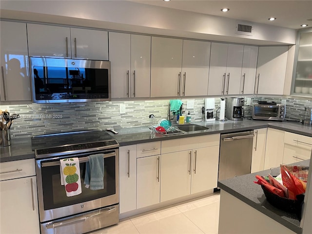 6039 Collins Ave Unit 1525, Miami Beach, FL 33140 - kitchen with appliances with stainless steel finishes, dark countertops, tasteful backsplash, and recessed lighting