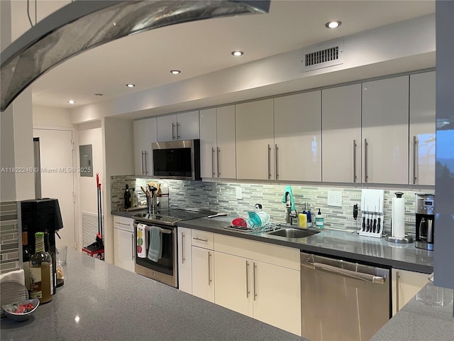 6039 Collins Ave Unit 1525, Miami Beach, FL 33140 - kitchen featuring stainless steel appliances, backsplash, dark stone counters, and recessed lighting