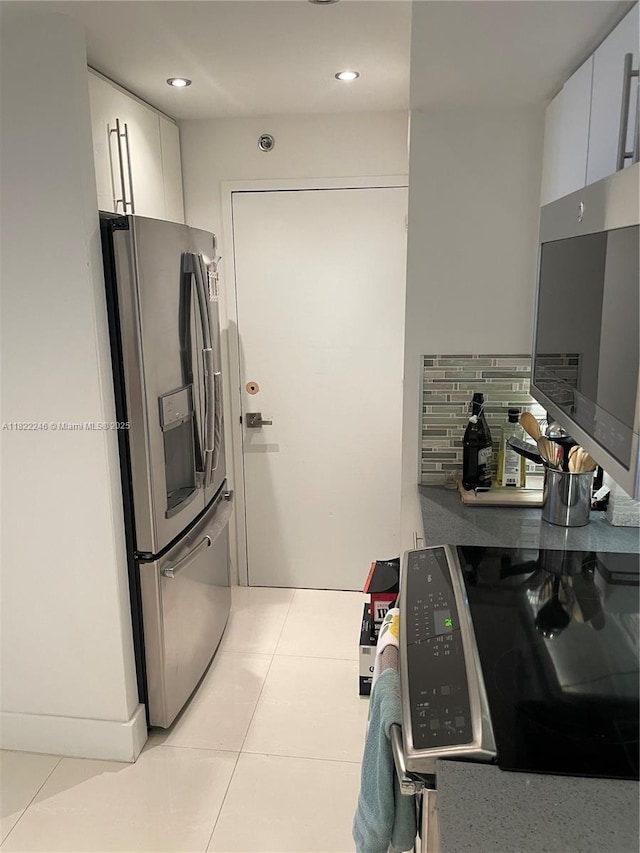 6039 Collins Ave Unit 1525, Miami Beach, FL 33140 - kitchen featuring stainless steel appliances, white cabinetry, recessed lighting, and light tile patterned floors