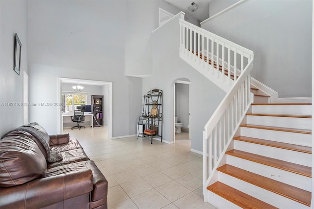 19257 NW 14th St, Pembroke Pines, FL 33029 - tiled living area with arched walkways, a towering ceiling, stairs, and a chandelier