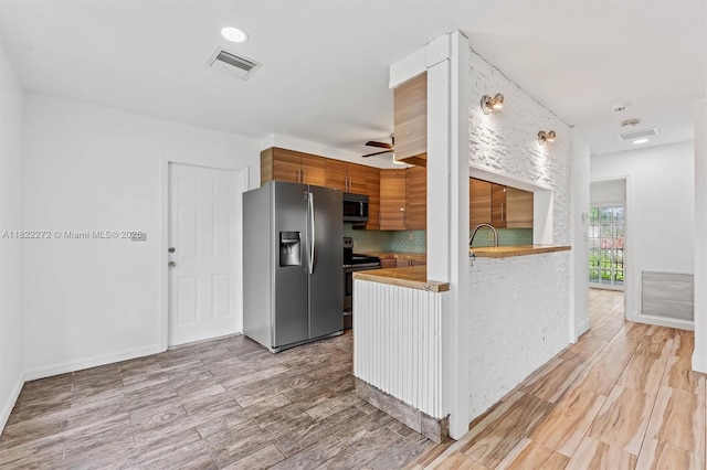 6073 NW 27th St, Margate, FL 33063 - kitchen with stainless steel appliances, light wood-type flooring, a ceiling fan, brown cabinetry, and modern cabinets