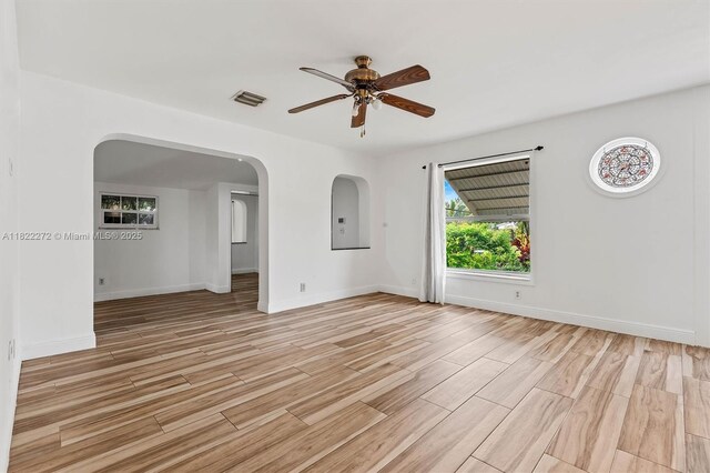 6073 NW 27th St, Margate, FL 33063 - empty room featuring arched walkways, ceiling fan, and light wood finished floors