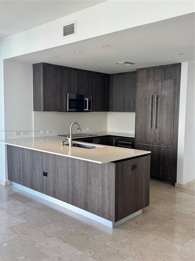 88 SW 7th St Unit 3012, Miami, FL 33130 - kitchen featuring stainless steel microwave, modern cabinets, a peninsula, and light countertops