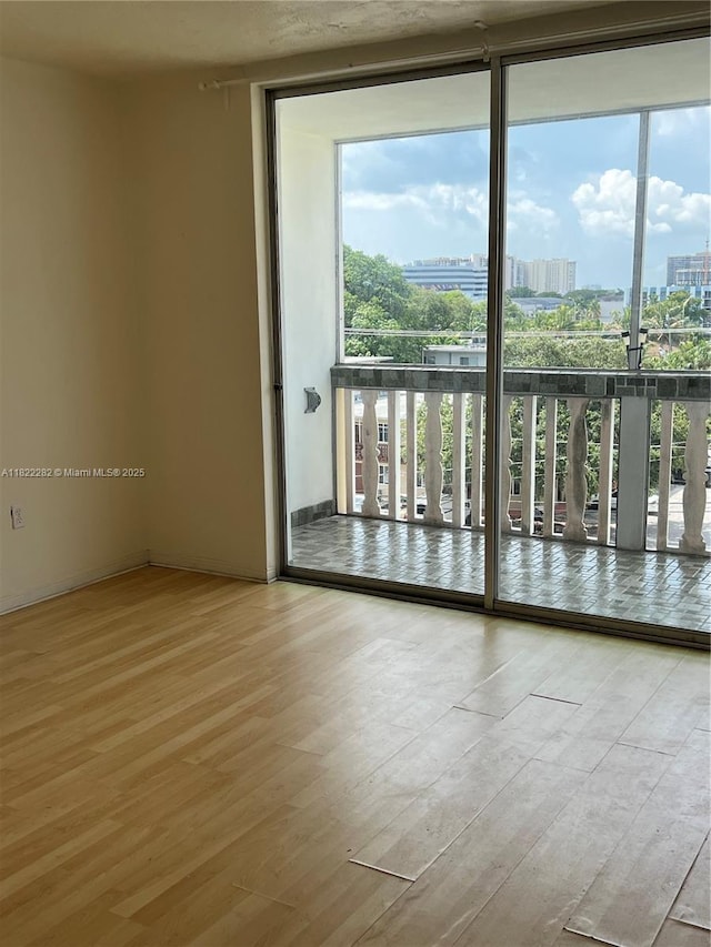 1475 NE 125th Ter Unit 511B, North Miami, FL 33161 - spare room with wood finished floors, a city view, and a wall of windows
