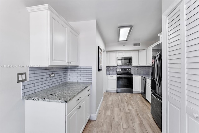 7225 Promenade Dr Unit 102, Boca Raton, FL 33433 - kitchen with appliances with stainless steel finishes, decorative backsplash, white cabinetry, light stone counters, and light wood finished floors