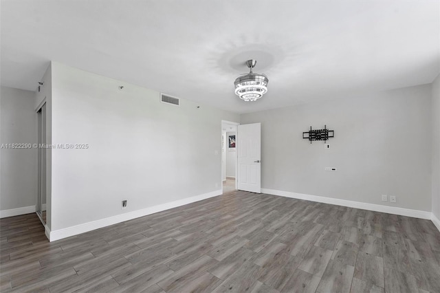 7225 Promenade Dr Unit 102, Boca Raton, FL 33433 - unfurnished room with wood finished floors and a chandelier
