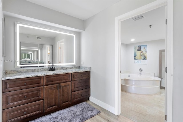 7225 Promenade Dr Unit 102, Boca Raton, FL 33433 - bathroom featuring wood finished floors, a bath, and vanity