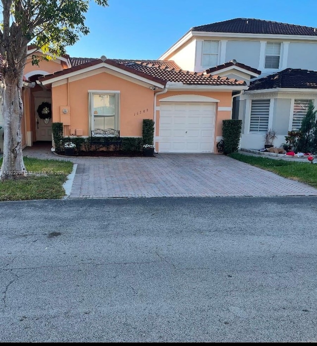 16388 SW 47th Ter, Miami, FL 33185 - townhome / multi-family property with driveway, stucco siding, a tile roof, and an attached garage