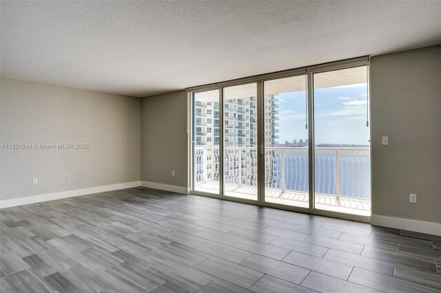 1200 Brickell Bay Dr Unit 2501, Miami, FL 33131 - unfurnished room with a textured ceiling, wood finished floors, and expansive windows