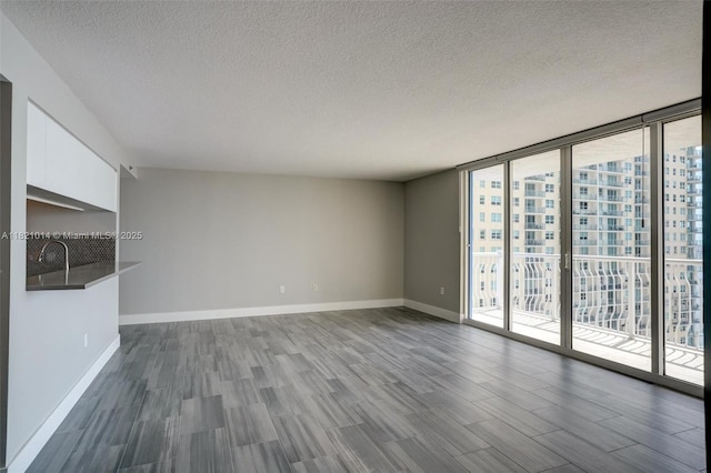 1200 Brickell Bay Dr Unit 2501, Miami, FL 33131 - unfurnished living room featuring a wall of windows, dark wood-style floors, and a textured ceiling