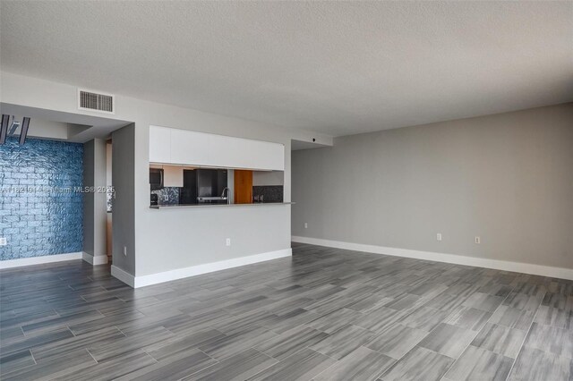 1200 Brickell Bay Dr Unit 2501, Miami, FL 33131 - unfurnished living room featuring dark wood-style floors and a textured ceiling