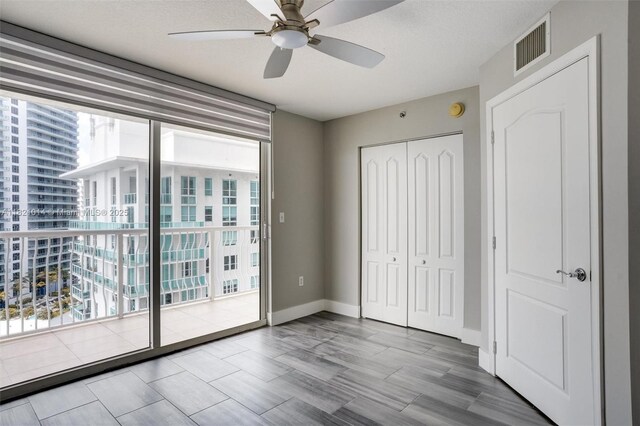 1200 Brickell Bay Dr Unit 2501, Miami, FL 33131 - unfurnished bedroom featuring a closet, ceiling fan, and access to outside