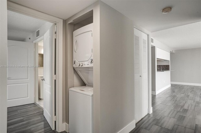 1200 Brickell Bay Dr Unit 2501, Miami, FL 33131 - washroom featuring estacked washer and dryer and dark wood-style flooring