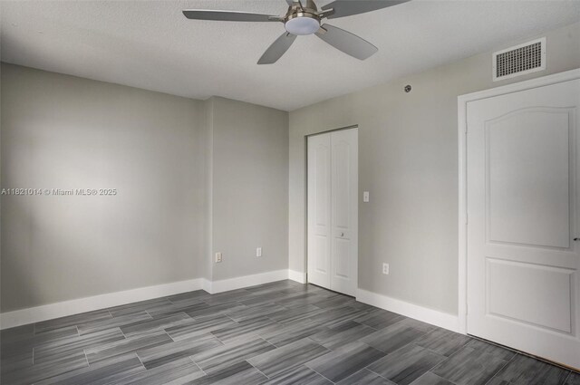 1200 Brickell Bay Dr Unit 2501, Miami, FL 33131 - unfurnished bedroom featuring dark wood-style flooring, a closet, a ceiling fan, and a textured ceiling