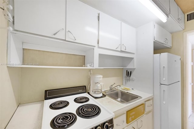 9920 Collins Ave Unit 2, Bal Harbour, FL 33154 - kitchen featuring range, freestanding refrigerator, open shelves, light countertops, and white cabinetry