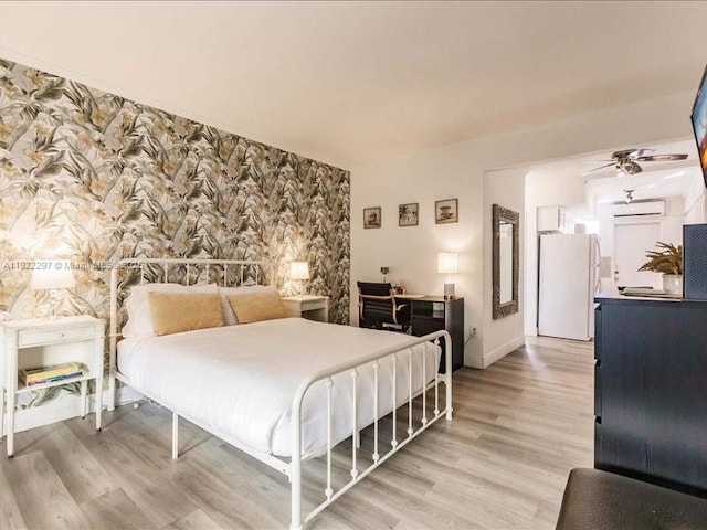 4015 Indian Creek Dr Unit 204, Miami Beach, FL 33140 - bedroom featuring freestanding refrigerator, light wood-type flooring, and wallpapered walls