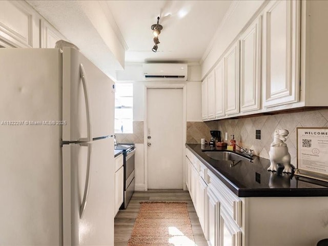 4015 Indian Creek Dr Unit 204, Miami Beach, FL 33140 - kitchen featuring freestanding refrigerator, stainless steel electric range oven, a wall mounted air conditioner, dark countertops, and decorative backsplash