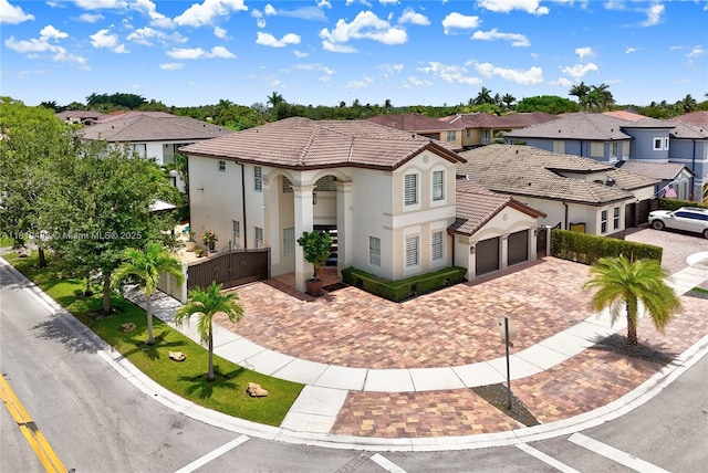 8902 NW 178th Ln, Hialeah, FL 33018 - mediterranean / spanish home featuring a residential view, a tiled roof, decorative driveway, an attached garage, and stucco siding
